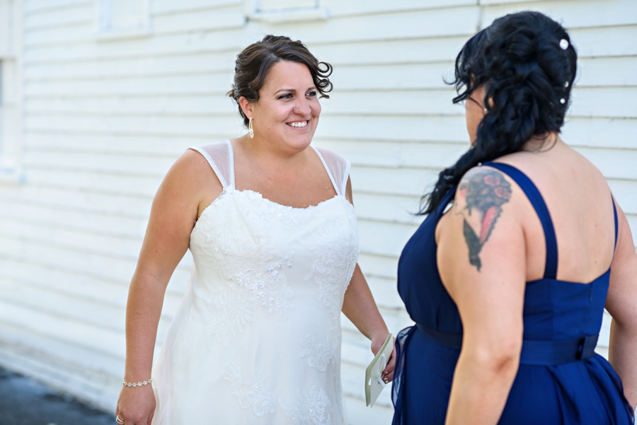 A bride and her sister laughing before the first look.